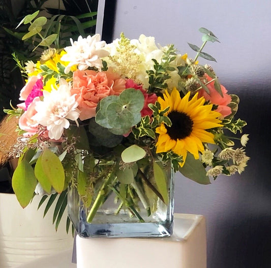 sunflowers hydrangeas and roses in a glass vase